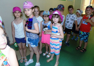 Dzieci w parach stoją na korytarzu.