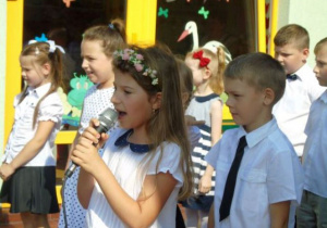 Dziewczynka śpiewa piosenkę, dzieci w tle