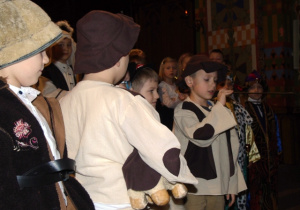 Chłopiec w stroju pastuszka mówi do mikrofonu.