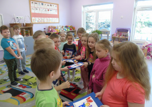 Chłopcy wręczają dziewczynkom laurki z okazji Dnia Kobiet.