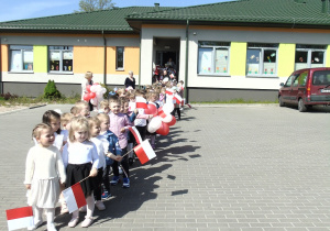 Dzieci wyruszają na pochód z flagami.